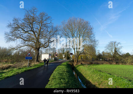 Giovane camminando sul Fen Road verso il fiume Foto Stock