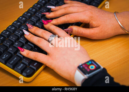 Signora con chiodi colorati in ufficio Foto Stock