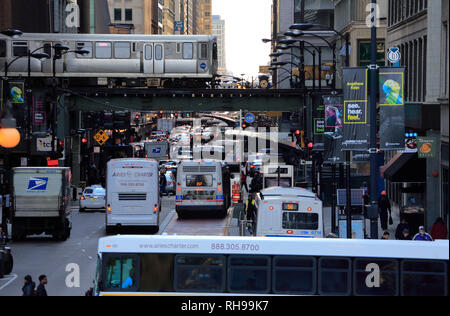 L Avviso di treno in marcia elevata su binari del treno con traffici di strada sotto in Chicago Loop in serata durante le ore di punta.Chicago.Illinois.USA Foto Stock