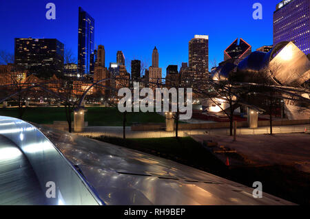 Vista notturna del centro di Chicago skyline con BP ponte pedonale il primo ponte progettato da Frank Gehry nel mondo in primo piano.Chicago.IL.USA Foto Stock