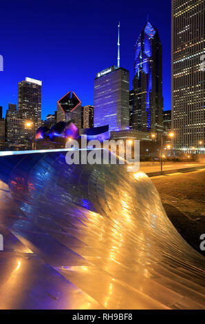 Vista notturna del centro di Chicago skyline con BP ponte pedonale il primo ponte progettato da Frank Gehry nel mondo in primo piano.Chicago.IL.USA Foto Stock