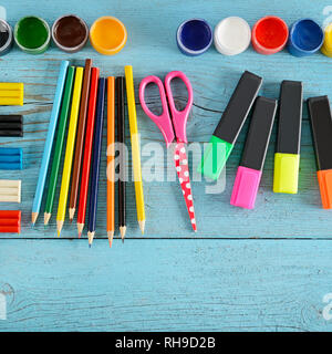 Forniture scolastiche (forbici, vernici, creta per modellare, marcatori matite) su sfondo di legno. Vista dall'alto. Copia dello spazio. Foto Stock