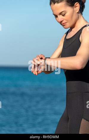Runner donna controllando il suo smart watch Foto Stock