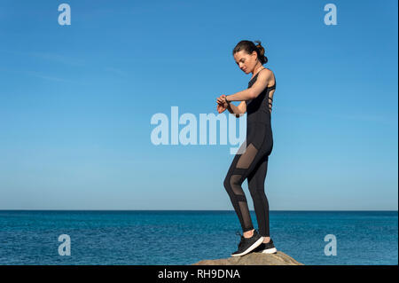 Runner donna controllando il suo smart watch Foto Stock
