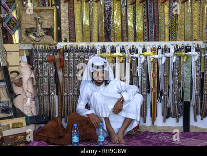 Arabia uomo vendono cinture e janbiya pugnali, Najran provincia Najran, Arabia Saudita Foto Stock