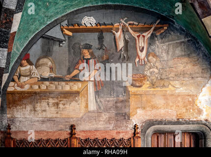 Italia Valle d'Aosta Issogne il castello - Cortile - galleria affrescata -il panettiere incendi il fresco pane impastato e il panettiere gira allo spiedo mentre un gatto cerca di rubare la carne Foto Stock