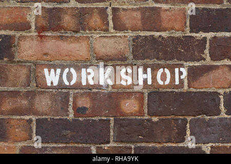 Segno del workshop con parole impresse su un vecchio vintage o stile grunge muro di mattoni Foto Stock