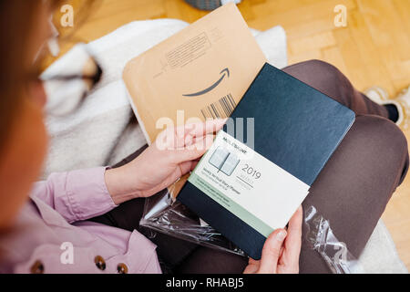 Parigi, Francia - Jan 7, 2018: vista aerea di donna unboxing ammirando nuovi MOLESKINE SETTIMANALI Diario verticale nel suo soggiorno Foto Stock