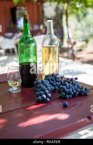 Due bottiglie di rosso e bianco vino della casa stand su un di legno Foto Stock