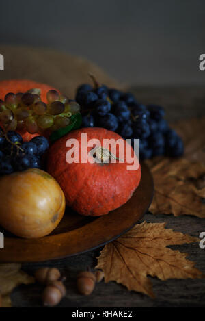 Felice per la festa del Ringraziamento concetto. Ancora la vita di foglie di autunno, zucca e frutti su tavola in legno rustico. Foto Stock