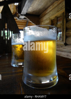 Due bicchieri di birra sul tavolo al pub in stile country Foto Stock