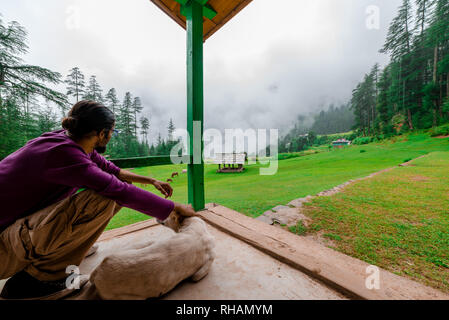 Kullu, Himachal Pradesh, India - 02 Settembre 2018 : Traveler con il cane nel portico in Himalaya, Himachal, India Foto Stock