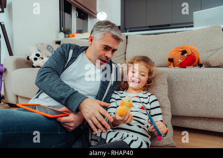 Bello grey-haired padre alti con un orologio rosso sulla sua mano guardando scioccato Foto Stock