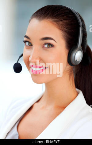 Closeup shot di giovani piuttosto call center lavoratore con cuffia Foto Stock