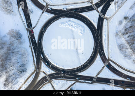 Antenna vista dall'alto in basso di rotonda in inverno con il traffico e la neve - Immagine Foto Stock