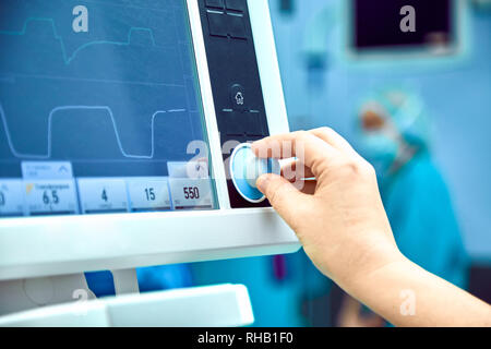 Monitoraggio di segno vitale del paziente in sala operatoria. medico cheking presso i segni vitali del paziente. Monitor Cardiogram durante gli interventi chirurgici in sala operatoria. Foto Stock