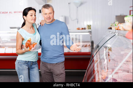 Coppia positiva ai clienti la scelta di carne in macelleria Foto Stock