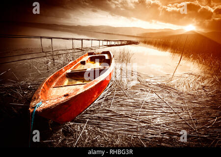 Vecchia barca sul lago al tramonto Foto Stock