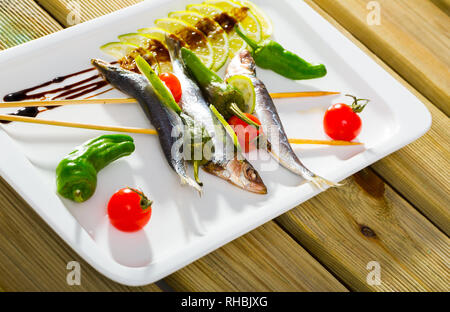 Lo spratto alla griglia con verdure fresche, servita con calce e pasta di aceto balsamico Foto Stock