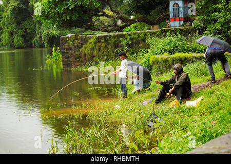 MAHARASHTRA, INDIA, agosto 2018, uomini di pesca in fiume con aste Foto Stock