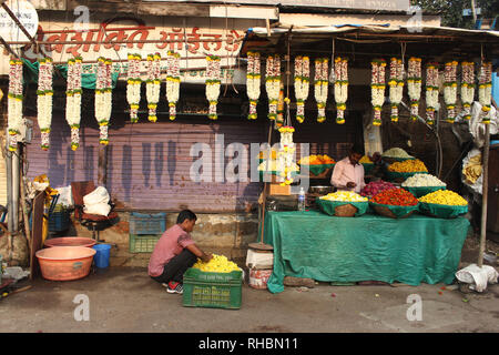 PUNE, Maharashtra, ottobre 2018, venditore di fiori presso il suo negozio in un mercato dei fiori Foto Stock