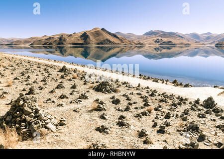 Cairns accanto al lago Yamdrok, Tibet Foto Stock