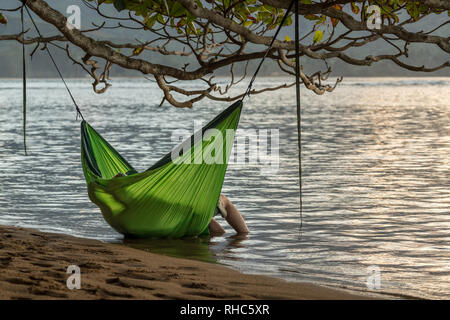 Cuddling matura in oscillazione amaca immersione in mare Foto Stock