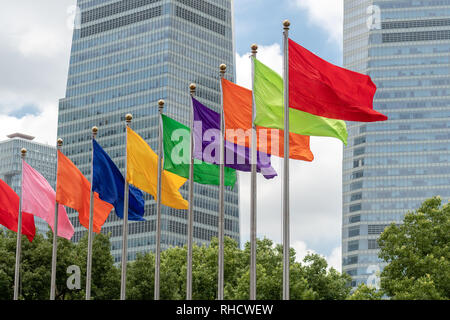 Varie di colore unico bandiere flyig da una serie di pali di bandiera a Shanghai in Cina Foto Stock