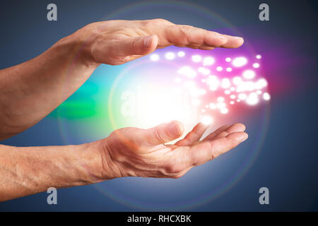 Close-up di una persona della mano che tiene la luce contro lo sfondo lucido Foto Stock