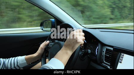 Le dita delle mani del conducente afferrare il volante in auto sulla velocità Foto Stock