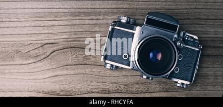 'Fotocamera retrò su sfondo di legno. Immagine panoramica con copia spazio. Foto Stock