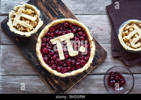 Pi giorno ciliegia e torte di mele - rendere tradizionali fatti in casa varie torte con Pi segno per marzo xiv vacanza, sul legno rustico sfondo, vista dall'alto, co Foto Stock