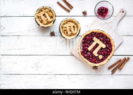 Pi giorno ciliegia e torte di mele - rendere tradizionali fatti in casa varie torte con Pi segno per marzo XIV, vacanze in bianco sullo sfondo di legno, vista dall'alto, cop Foto Stock