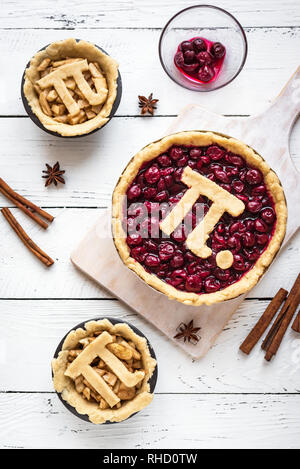 Pi giorno ciliegia e torte di mele - rendere tradizionali fatti in casa varie torte con Pi segno per marzo XIV, vacanze in bianco sullo sfondo di legno, vista dall'alto. Foto Stock