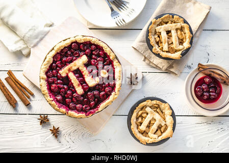 Pi giorno ciliegia e torte di mele - tradizionali fatti in casa varie torte con Pi segno per marzo XIV, vacanze in bianco sullo sfondo di legno, vista dall'alto. Foto Stock