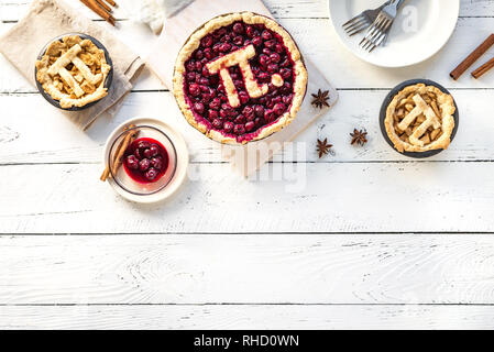 Pi giorno ciliegia e torte di mele - tradizionali fatti in casa varie torte con Pi segno per marzo XIV, vacanze in bianco sullo sfondo di legno, vista dall'alto, spazio di copia Foto Stock