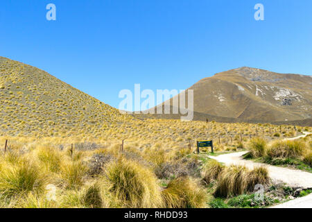 La passerella sull'autostrada a viewpoint in Lindis Pass paesaggio tussock colline coperte Foto Stock