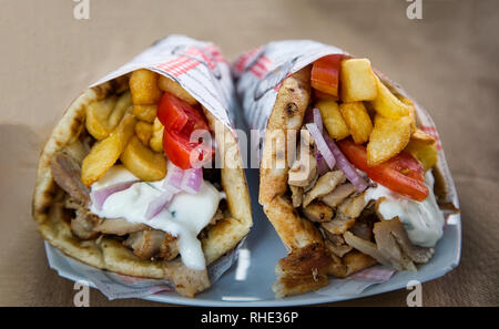 Il greco gyros pita con carne tritata, patatine fritte, pomodori e salsa tzatziki Foto Stock