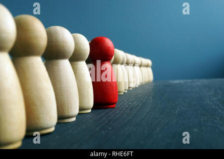 Sviluppo della leadership. Linea di statuette in legno con uno rosso. Foto Stock