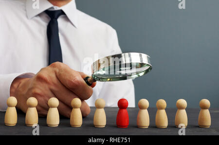 Selezionatore guardando attraverso la lente di ingrandimento sui candidati. Assunzione e reclutamento del personale. Foto Stock