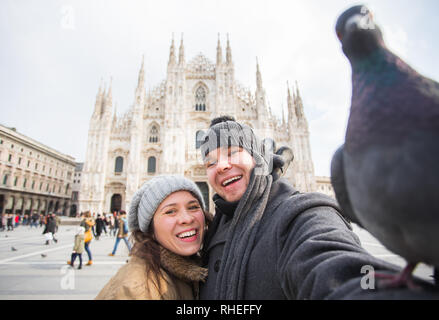 Viaggi, Italia e divertente giovane concetto - Happy turisti prendendo un autoritratto con piccioni nella parte anteriore del Duomo di Milano Foto Stock