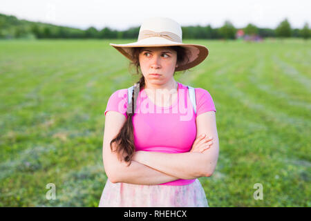 Cupo annoiato ragazza acciglia faccia rivolta a parte. Arrabbiato sullen donna in piedi all'aperto in attesa di risposte. Foto Stock