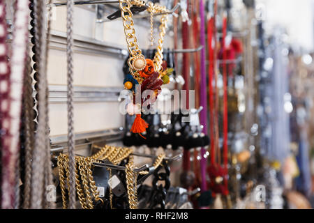 Un sacco di bei orecchini colorati e accessori diversi sul supporto in negozio Foto Stock