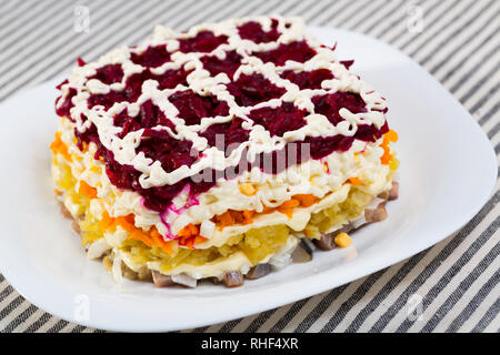 Insalata con dadini di stratificata aringhe in salamoia e grattugiato verdure bollite Foto Stock