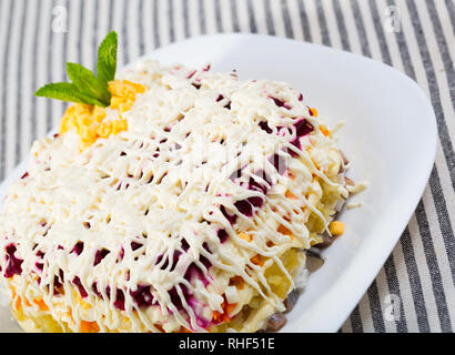 Insalata con dadini di stratificata aringhe in salamoia e grattugiato verdure bollite Foto Stock