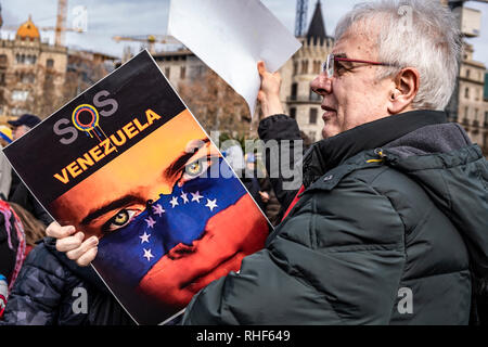 Un manifestante è visto tenendo un cartello di SOS Venezuela durante la protesta. I membri della comunità venezuelana in Barcellona che sostengono il presidente ad interim Juan Guaidó sono andati fuori per chiedere libere elezioni in Venezuela. Foto Stock