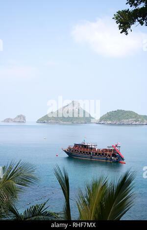 Crociera turistica di barca in Ang Thong National Marine Park riviera con le isole sagome sullo sfondo Foto Stock