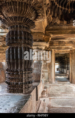 Belavadi, Karnataka, India - 2 Novembre 2013: Veera Narayana Tempio. Guardando attraverso il corridoio in gran parte anteriore aperta Mandapam. Altamente decorato nero Foto Stock