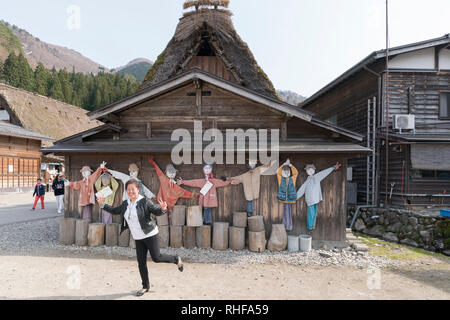 Tourist pone di fronte ad una tradizionale casa colonica nel villaggio di Ogimachi, Shirakawa-go, Giappone Foto Stock