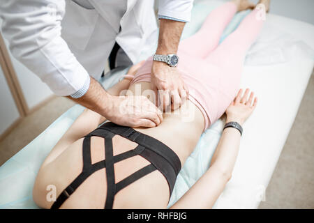 Close-up di fisioterapista facendo il trattamento manuale a una giovane donna con problemi della colonna vertebrale Foto Stock